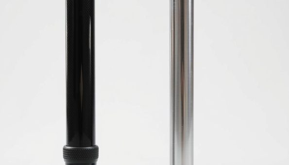 A detailed comparison of two ultralight trekking poles - one made of sleek carbon fiber, the other rugged aluminum. The carbon fiber pole stands tall, its glossy black surface reflecting the studio lighting. Next to it, the aluminum pole gleams with a silvery metallic sheen. The poles are angled slightly, allowing a clear side-by-side examination of their weight, thickness, and overall design. The background is a clean, neutral white, putting the focus squarely on the trekking poles and their defining features. The lighting is soft and evenly distributed, creating a sense of balance and clarity. This comparative image aims to highlight the lightweight advantages of carbon fiber over its aluminum counterpart. A detailed comparison of two ultralight trekking poles - one made of sleek carbon fiber, the other rugged aluminum. The carbon fiber pole stands tall, its glossy black surface reflecting the studio lighting. Next to it, the aluminum pole gleams with a silvery metallic sheen. The poles are angled slightly, allowing a clear side-by-side examination of their weight, thickness, and overall design. The background is a clean, neutral white, putting the focus squarely on the trekking poles and their defining features. The lighting is soft and evenly distributed, creating a sense of balance and clarity. This comparative image aims to highlight the lightweight advantages of carbon fiber over its aluminum counterpart.