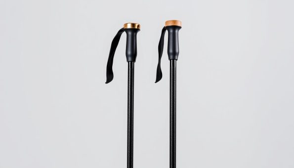 A pair of sleek, ultra-lightweight carbon fiber trekking poles stand upright against a plain, minimalist background. The poles' matte black finish gleams subtly, the intricate woven texture of the carbon fiber visible up close. Ergonomic cork grips crown the poles, their natural warmth and tactile surface complementing the modern, high-performance materials. Soft, diffused lighting gently illuminates the scene, casting subtle shadows that accentuate the poles' clean, angular design. The overall impression is one of quality, durability, and outdoor-ready functionality - a perfect representation of the "Design and Materials: Carbon Fiber and Cork Grips Excellence" section. A pair of sleek, ultra-lightweight carbon fiber trekking poles stand upright against a plain, minimalist background. The poles' matte black finish gleams subtly, the intricate woven texture of the carbon fiber visible up close. Ergonomic cork grips crown the poles, their natural warmth and tactile surface complementing the modern, high-performance materials. Soft, diffused lighting gently illuminates the scene, casting subtle shadows that accentuate the poles' clean, angular design. The overall impression is one of quality, durability, and outdoor-ready functionality - a perfect representation of the "Design and Materials: Carbon Fiber and Cork Grips Excellence" section.