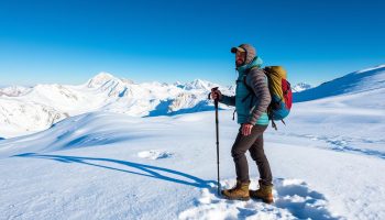 A rugged hiker stands in a snowy alpine landscape, their trekking poles firmly planted in the powdery white. The poles, crafted from gleaming 3K carbon fiber, are seamlessly integrated with a variety of outdoor gear - a weatherproof backpack, insulated jacket, and heavy-duty boots. Crisp sunlight illuminates the scene, casting long shadows across the undulating terrain. In the distance, jagged snow-capped peaks pierce the azure sky, hinting at the challenging but rewarding journey ahead. The hiker's confident posture and focused expression convey a sense of preparedness and determination, ready to tackle the treacherous terrain with their reliable trekking pole companions.